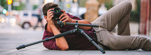 Fotógrafo de bodas apoyado sobre el suelo con su cámara sobre un trípode haciendo un contrapicado