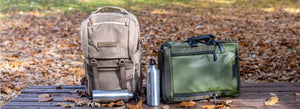 Mochilas para cámaras de formato medio apoyadas sobre un banco en un parque