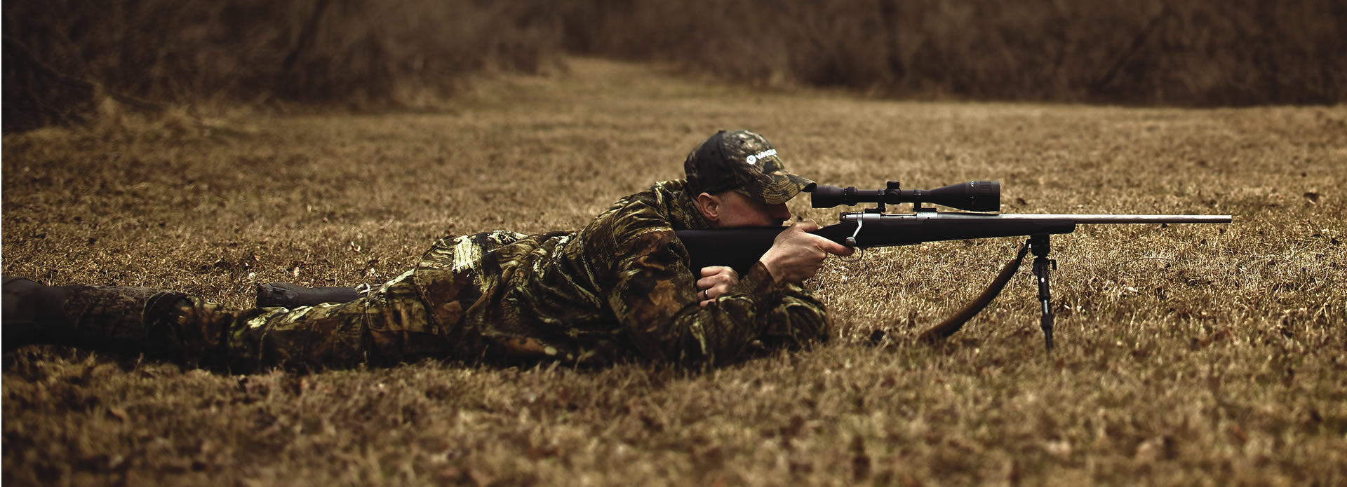 Cazador tumbado con su rifle apoyado sobre un bípode tipo Harris